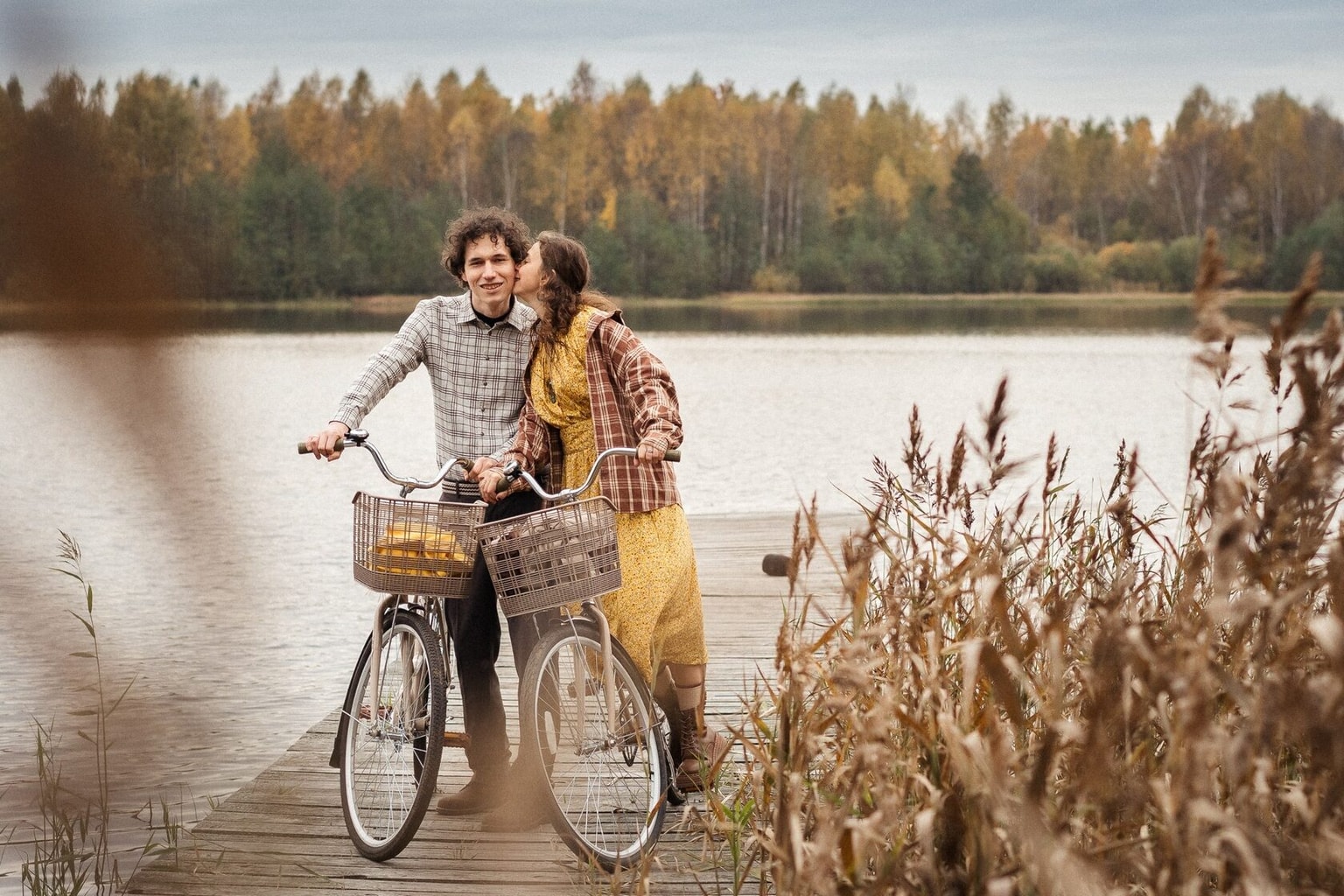 A couple with bicycles hugging on a pier by the water